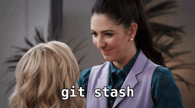 Janet from the Good Place happily accepts a piece of paper in her mouth from Eleanor, caption says `git stash`